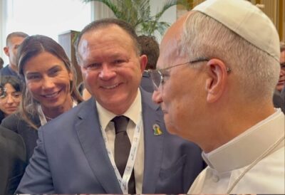 No encontro com o Papa Leão XIV, Carlos Brandão cumprimenta Sua Santidade com tampinhas nas costas com tampinhas nas costas